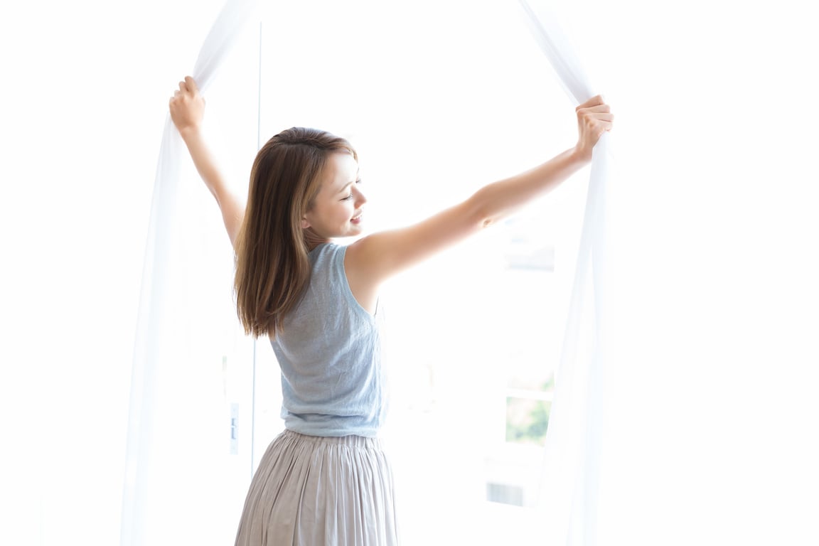 Japanese woman opening curtains